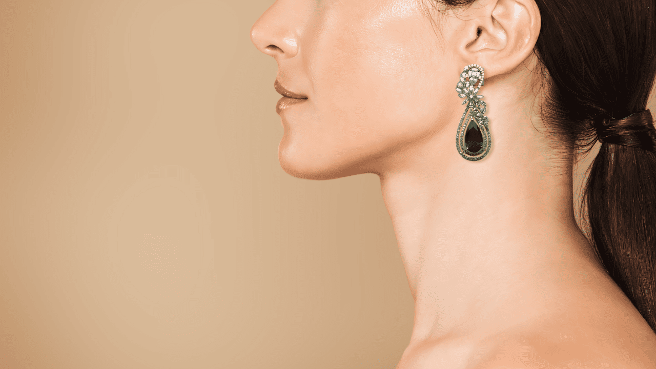 Woman wearing diamond and emerald earring Woman wearing diamond and emerald earring
